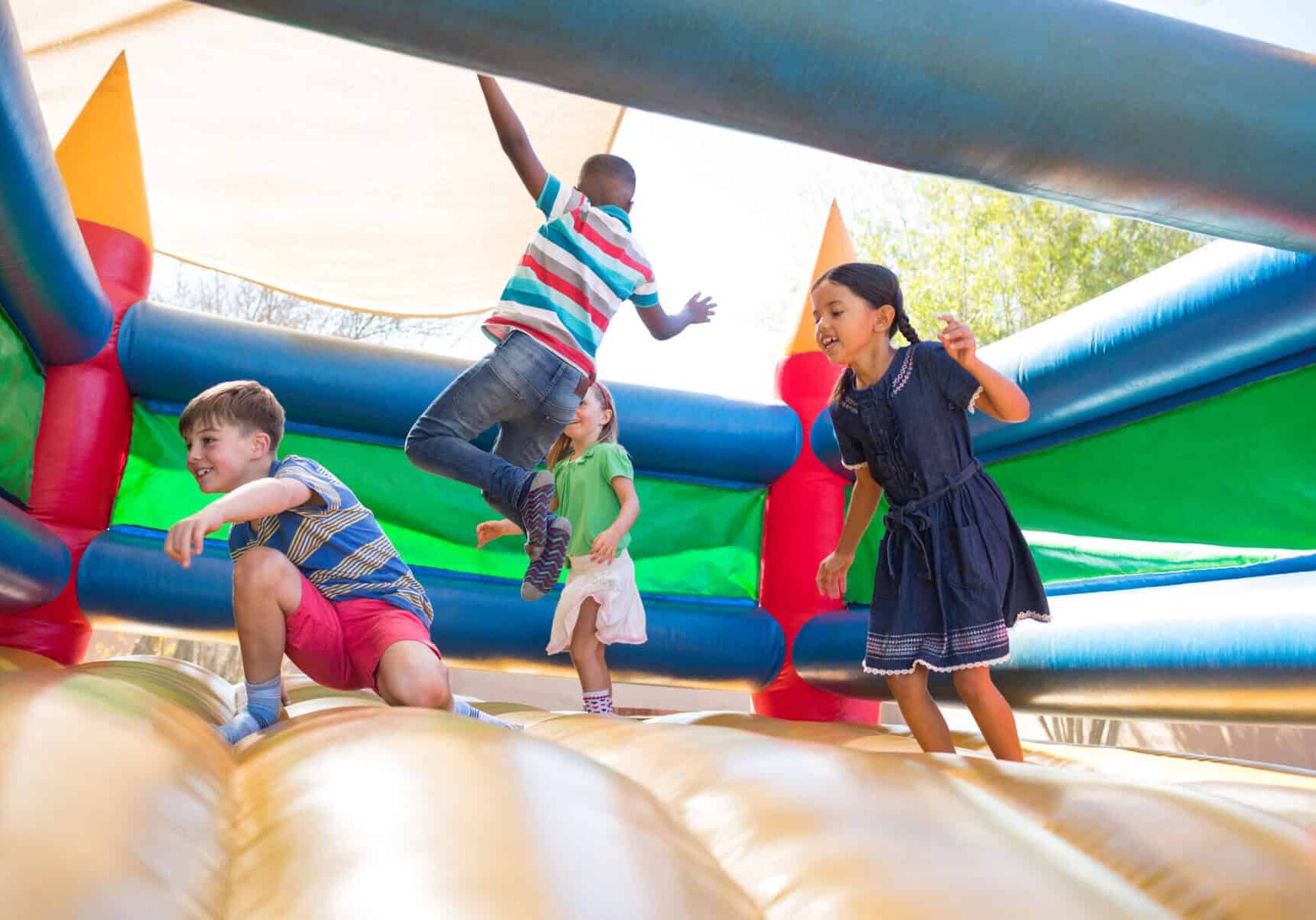 Friends jumping on bouncy castle at playground